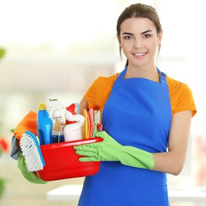 Young woman holding cleaning supplies