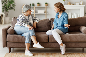 elderly and young woman talking on a couch