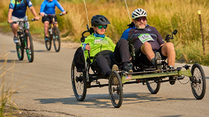 Josh Fohner riding a tandem e-bike with his dad Mike.