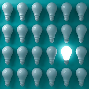 Rows of off lightbulbs with one on