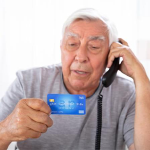 Elderly man reading his credit card information over the phone