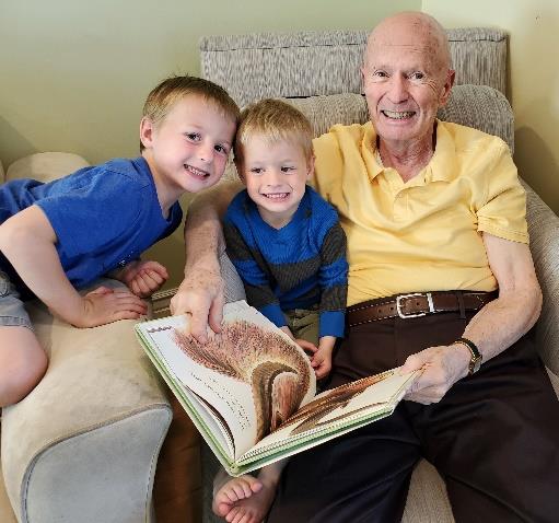 elderly man with his grandchildren reading