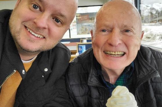eldery man getting ice cream with adult son