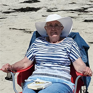 marti sitting in a chair on the beach