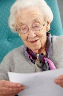 Elderly Woman looking at a sheet of paper\
