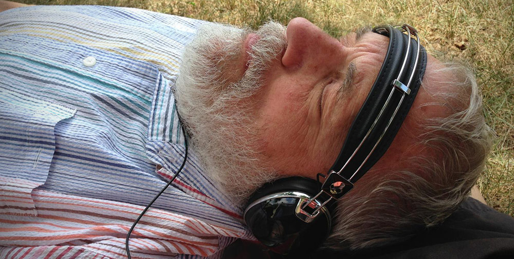 man laying in grass listening to some tastey jams